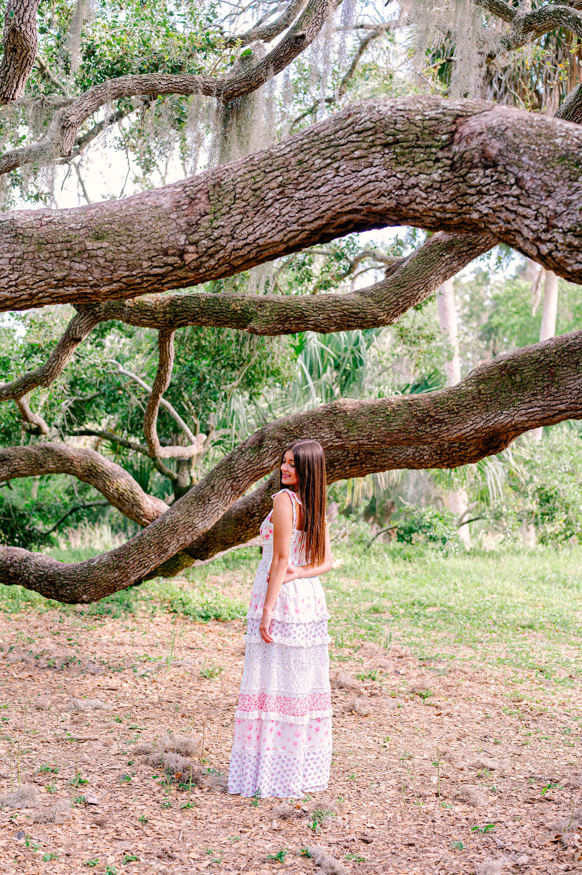FSU-bound senior twirling in long floral dress at Philippe Park captured by Tampa senior portrait photographer Nina Bashaw