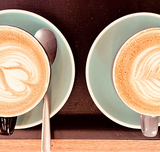 Grüne Kaffeetassen mit Milchschaum
