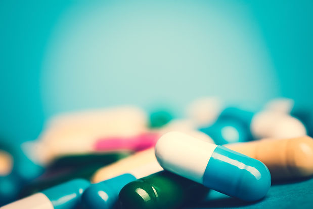 Medicine green and yellow pills or capsules on blue background with copy space. Drug presc