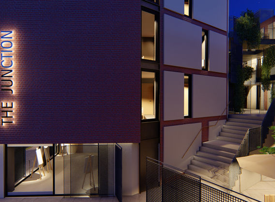 The Junction building with lit signage, multi-story structure and outdoor setting.