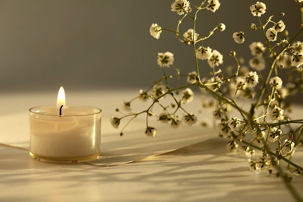 Brandende theelichtkaars met witte bloemen