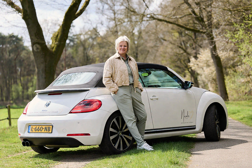 Nicole Jansen leunend tegen haar auto