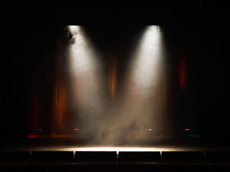 An empty theater stage with two spotlights