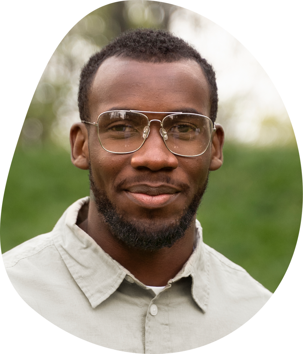 Young woman with blonde hair and a calm expression, against a plain gray background. She wears a black top, and her eyes look forward.