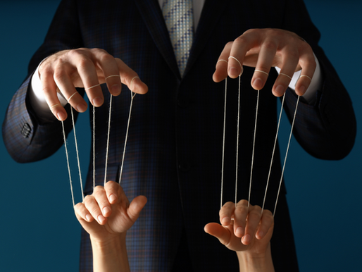 A man's hands controlling a woman's hands with puppet strings.