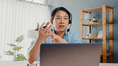 young-asia-businessman-wear-headphones-using-laptop-talk-colleagues-about-plan-video-call-