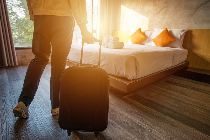 Walking into hotel room with suitcase.jp