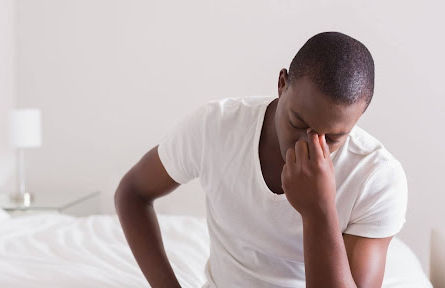 Person waking up feeling tired and regretful after drinking the night before