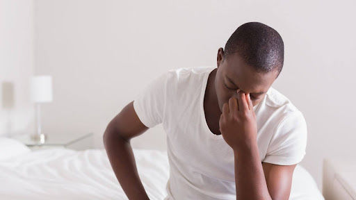 Person waking up feeling tired and regretful after drinking the night before