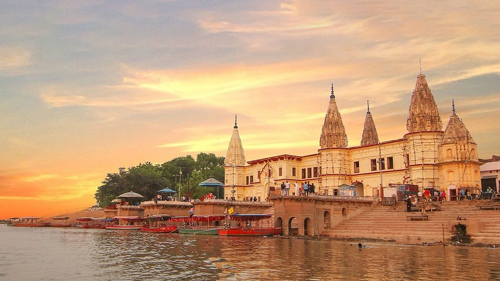 Saryu Ghat in Ayodhya at sunset with riverside temples, steps, boats and devotees near the sacred Saryu River.