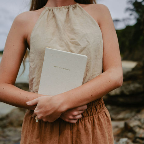A woman journaling in a peaceful Bali setting, surrounded by lush greenery, with a open notebook and morning coffee — capturing the stillness of a daily writing ritual.