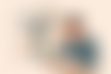 Man with a hand on his forehead, looking sad. Background has a bare tree and potted plant. Earth tones set a somber mood.