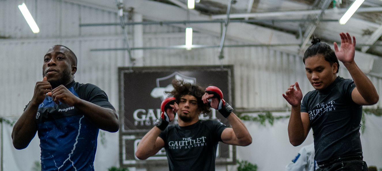 Three MMA  coachs teaching a class