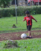 Tico boy kicking soccer ball