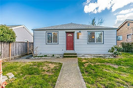 A single story light blue home with a red door