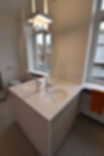 Modern wit badkamermeubel in Solid Surface met ronde spiegel.