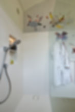 Douche in projecten in Solid Surface met badjas aan wand.