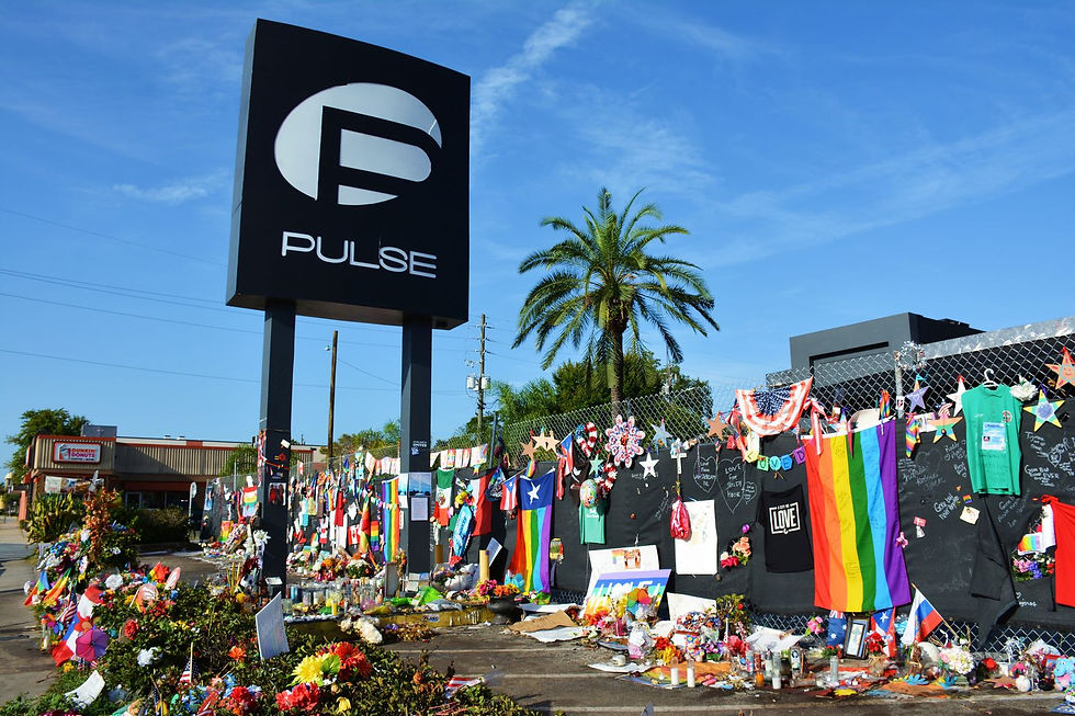 The sign for Pulse Nightclub stands above a fence lined with rainbow flags and artwork to remember the 49 victims of the June 12, 2016 tragedy inside this building.