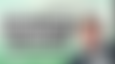 Smiling person in a suit on right; left text reads "Beyond the Label: Neurodiversity & the Workplace, Saturday 4th April." Green background.