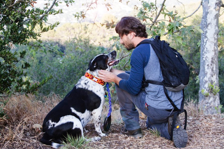 man and dog with handmade collar and leash in park