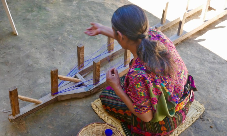 Indigenous artisan woman prepares típico thread for weaving