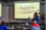 Presenter Symphony Swan speaks about Emergent Strategies with a slide displaying a theme from the book.
