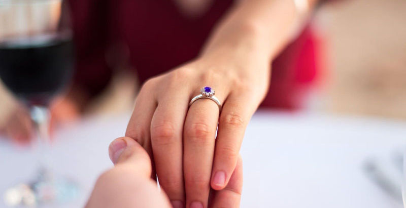 man proposing with a sapphire ring
