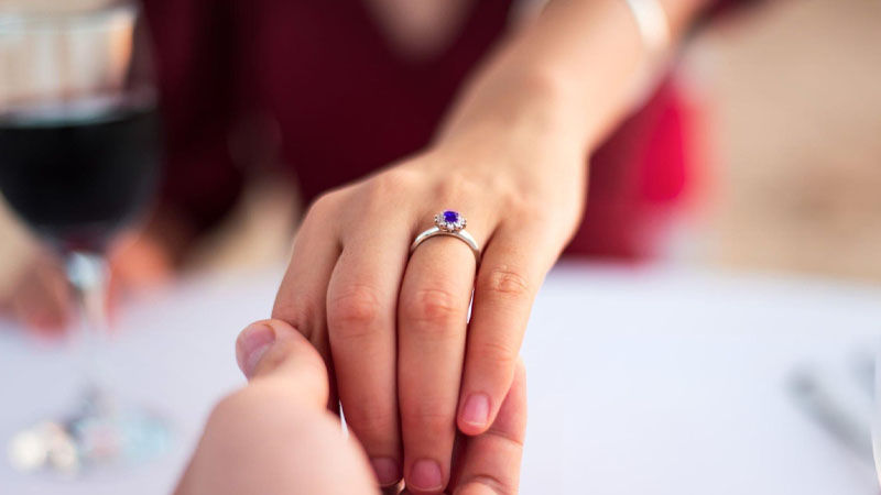 man proposing with a sapphire ring