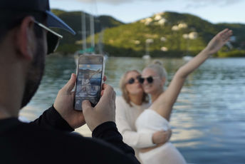 Person taking a photo of friends by the waterfront.