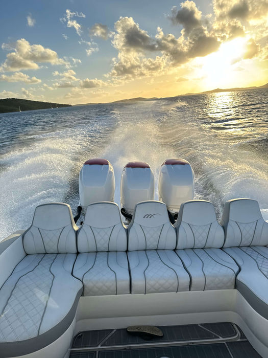 A speedboat moving fast at sunset.