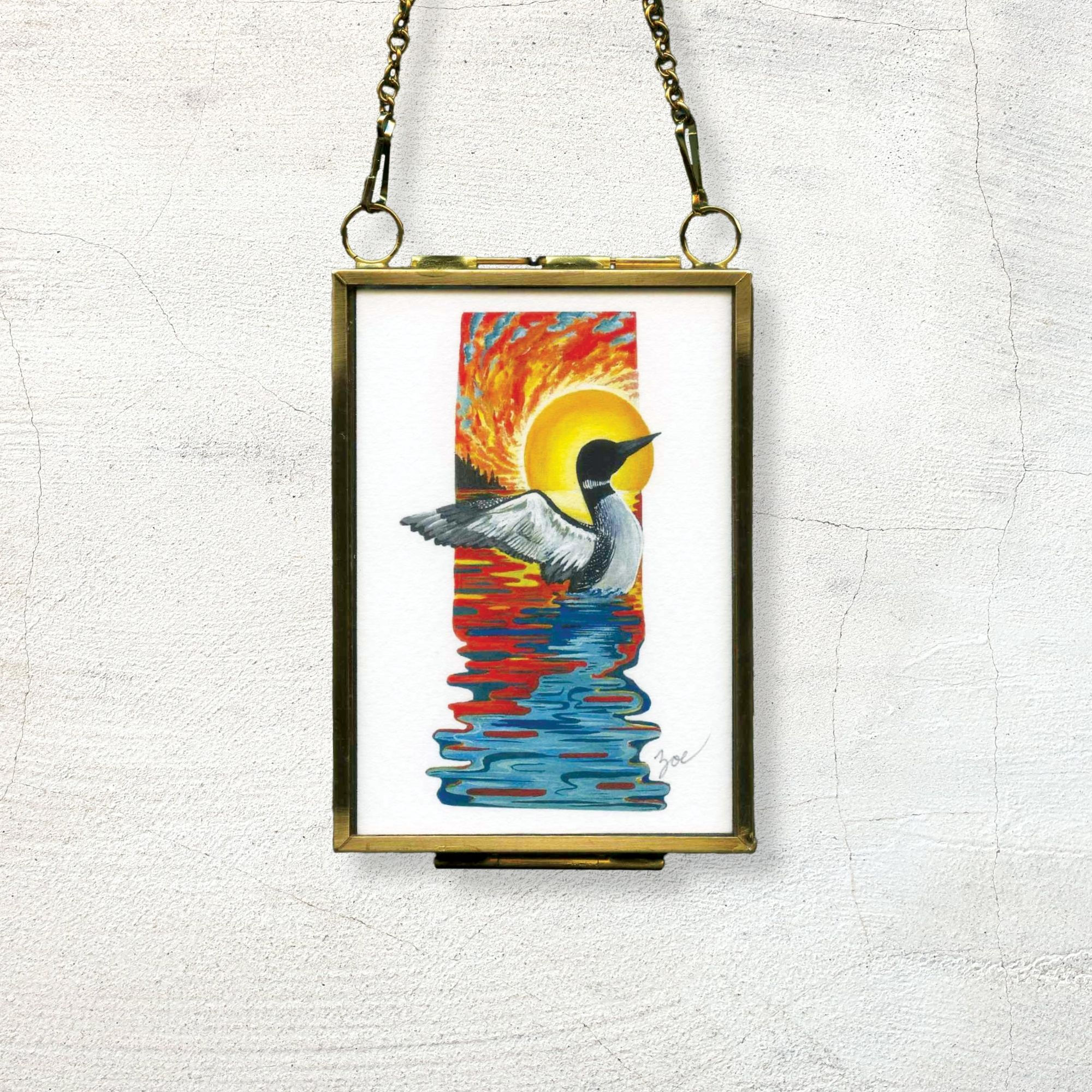 Striking artwork of a loon spreading its wings against a colorful, vibrant sunset and lake, mini giftable art print keepsake