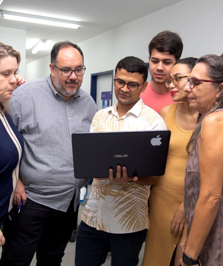 Diverse team collaborating over a laptop in an office