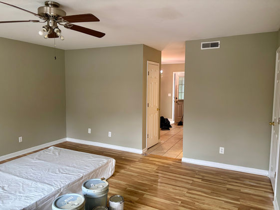 Room with wooden floor, ceiling fan, and paint cans. Apartment painting, turnover service in Cookeville, TN