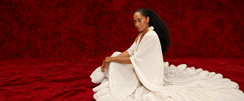 Seated woman in ivory dress against red.png