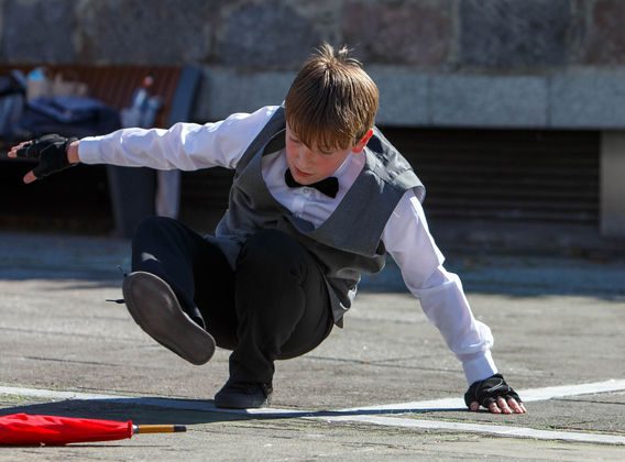 Bring it Boy dancer with umbrella on the floor, doing a Hip Hop trick on the ground.