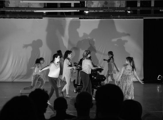 Horizons performance group walking in a circle with their arms raised at their sides.