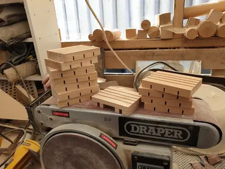 wooden soap dish holders sitting on a Draper sander during batch production