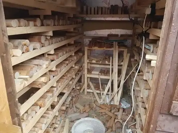 Spindle blanks stacked and air-drying on racks in a small woodturning drying store
