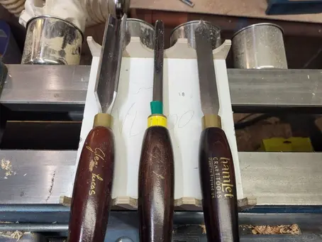 3 woodturning tools in a DIY cradle on a lathe bed with magnetic cups in the background