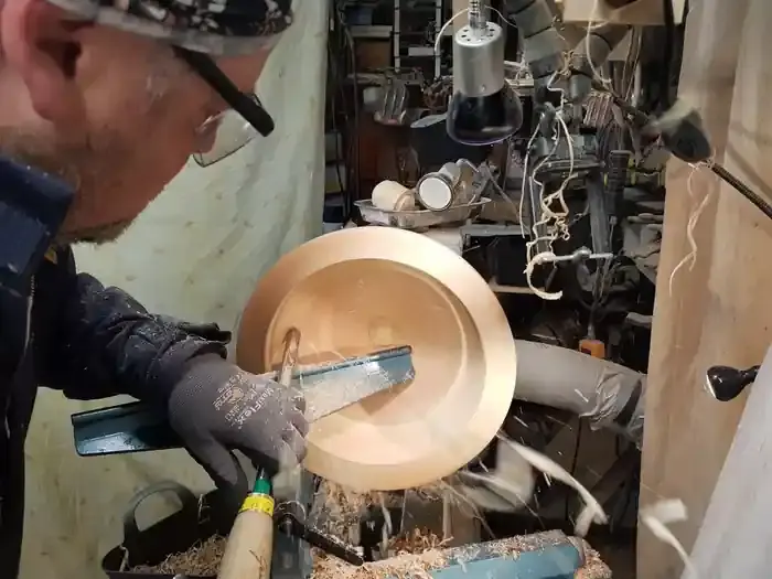 Woodturner David Condon rough turning a greenwood Sycamore Bowl with a Bowl Gouge with shavings flying