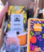 cardboard shipping box full of dark chocolate, labradorite tumble, Palo Santo, glass vial of matches, kleenex