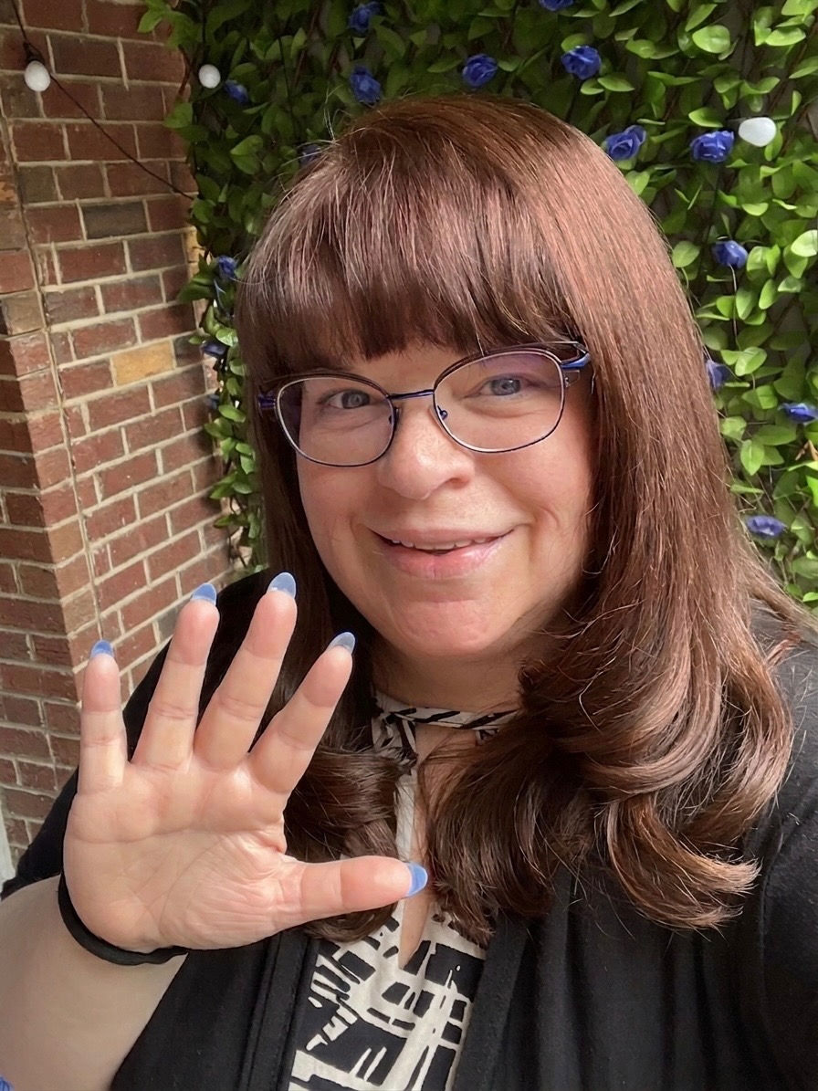 Portrait photo of Diana waving at the camera
