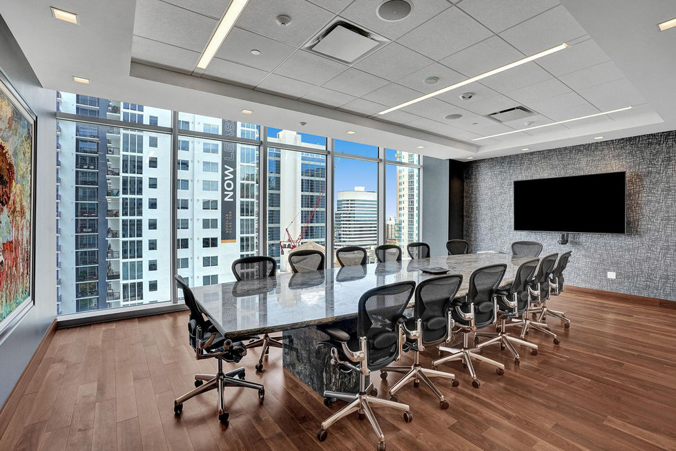 a conference room with a large table and chairs and a sign on the wall that says now