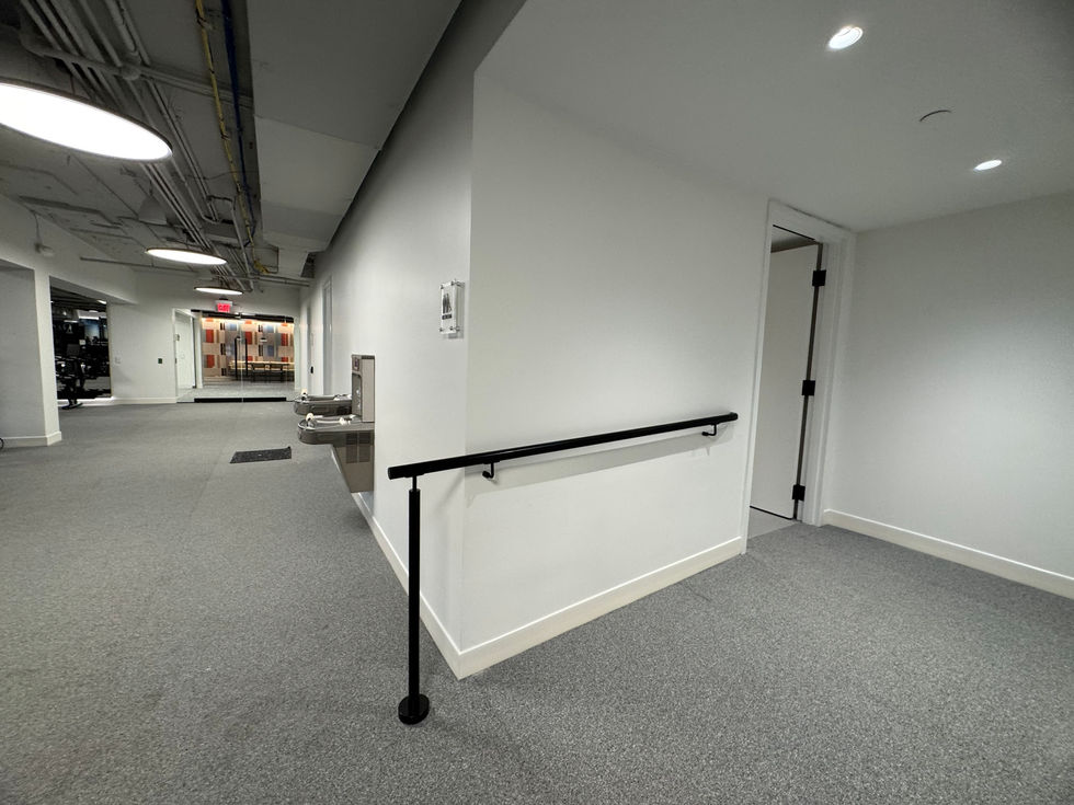 Lower lobby and tenant gym at One Biscayne Tower, Miami — modern interiors with fitness equipment.