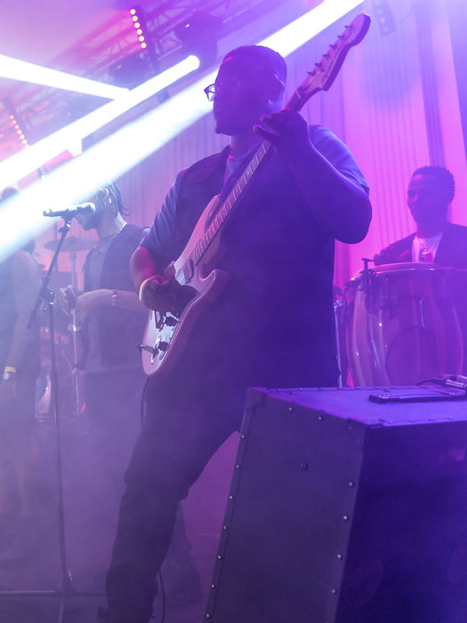 Groupe jouant sur scène, lumières vives