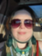 A picture of Melinda, smiling in a car with a neck brace on.