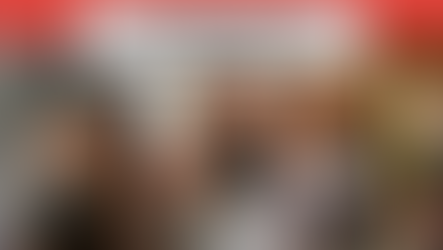 People in masks discuss MN Long COVID funding risk. Text: "SOS: #MEAction Responds to Urgent Crisis." Group in office setting.