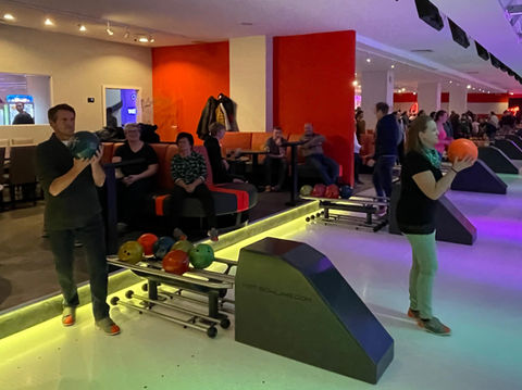 Gruppe von Personen beim Bowling in einer modernen Bahn.