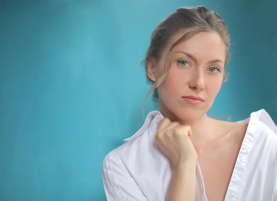 closeup-shot-pretty-female-with-white-shirt-isolated-blue.webp