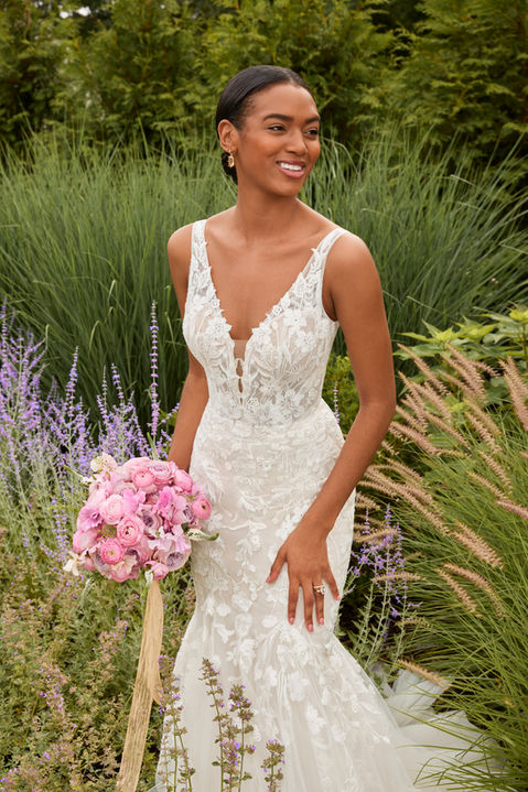 Our Sydney designer wedding dress is classic bridal beauty. The fitted gown has a plunging v-neckline that elongates the body and draws the eye down to the flared tulle skirt. Delicate floral embroidered lace appliqués have a feminine and romantic feel, accenting the sheer open back and climbing up the straps. Godet insets on the train add texture and drama.